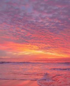 the sun is setting over the ocean with pink clouds