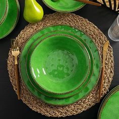 a table set with green plates and silverware