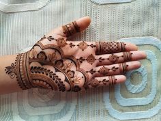 a woman's hand with henna tattoos on it