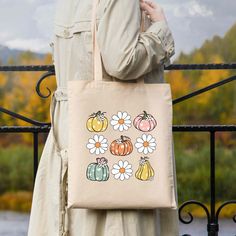 Celebrate autumn with the Cutest Pumpkin In The Patch Canvas Tote Bag—a stylish and eco-friendly accessory that perfectly captures the season’s charm. Made from 100% cotton canvas, this tote showcases a playful pumpkin design, making it the perfect companion for your fall outings. Whether you're off to the market, enjoying a crisp autumn walk, or just running errands, this durable bag provides ample space for your essentials while promoting sustainability. Features: Size: 14 1/2" W x 15 1/2" H w Fall Outings, Cutest Pumpkin In The Patch, Autumn Walk, Eco Friendly Accessories, Crisp Autumn, Fall Feels, Trendy Tee, Cute Pumpkin, Pumpkin Design