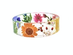 This is a stunning bangle, filled with beautiful real flowers - orange daisy, blue cornflower, yellow buttercup, surrounded by rich green fern leaves, and gorgeous white and orange baby's breath flowers. It is a chunky bangle with a straight profile - the same thickness around the entire circumference of the piece. Available sizes: Size XS Inside diameter 2 9/32" (58mm) wide 3/4" (18mm) thick 1/8" (4mm) Size S: Inside diameter 2 23/34" (60mm) wide 4/8" (15mm) thick 9/16" (6mm) Size M: Inside dia Orange Flower Bracelet For Gift, Multicolor Flower Jewelry With Pressed Flowers, Multicolor Flower Shaped Jewelry With Pressed Flowers, Adjustable Flower Bracelets With Pressed Flowers, Orange Daisy, Breath Flowers, Flowers Orange, Fern Leaves, Blue Cornflower