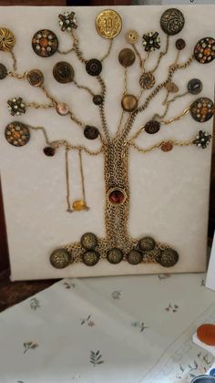 a tree made out of buttons and other items on a table with scissors next to it