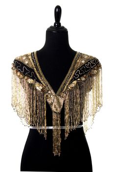 Talk about glam AND versatility. This shawl can be worn in multiple different ways and will reflect your own inner radiance out into the world! Hand-beaded fringe shawl Features embroidered circular mirrors and beads Opens in front - can be worn forward or backward Very Secure clasp at the front Imported Item Festive Sequin Shawl, Gold Bohemian Shawl For Wedding, Bohemian Gold Wedding Shawl, Gold Bohemian Wedding Shawl, Gold Shawl For Festive Evening, Gold Shawl For Festive Evening Events, Gold Shawl For Evening And Festive Occasions, Festive Gold Shawl For Evening, Festive Evening Gold Shawl