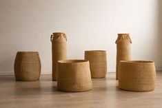 four woven baskets sitting on the floor next to each other