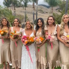 a group of women standing next to each other holding bouquets