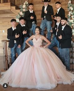 a group of men and women posing for a photo in front of a wedding dress