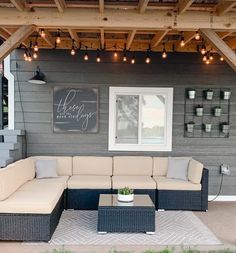 an outdoor living area with couches and lights