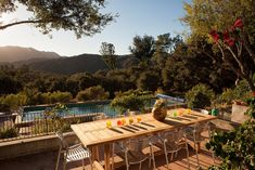 an outdoor dining area with table, chairs and view of the mountains in the distance