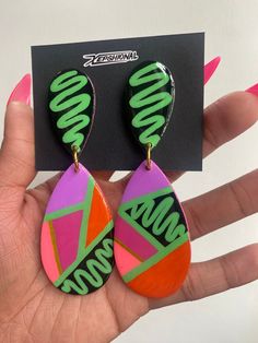 a pair of neon colored earrings with the word boooo written on them in black letters