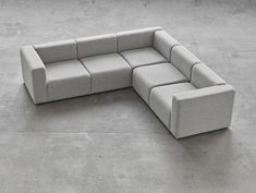 a gray couch sitting on top of a cement floor