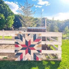 a wooden fence with a patchwork quilt on it