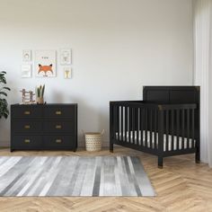 a baby's room with two black cribs and a rug on the floor