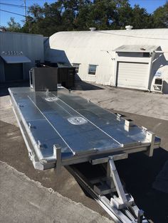 a flatbed trailer is parked in front of a building with an awning on it