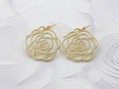 These are pair of beautiful camellia rose earrings. They are made with golden plated over brass flower shaped filigree pendants. The flower is available in two different golden color. The gold color is in a deep gold; and light gold color is in a light gold tone. The earrings measure about 31mm (1.25 inches) from the top of the ear wires to the bottom of the flower. They are perfect for many occasions, gift giving or as a little treat for yourself. Your earrings will presented in a jewelry gift Gold Flower Earrings For Bridesmaid Gift, Gold Rose Design Earrings For Anniversary, Gold Flower Earrings For Bridesmaids, Formal Gold Earrings With Rose Design, Elegant Rose Earrings With Ear Wire, Gold Flower Earrings For Wedding, Elegant Rose Dangle Earrings, Formal Gold Flower Earrings With Rose Design, Gold Rose Design Earrings For Wedding