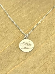 This beautiful necklace is a stainless steel laser engraved pendant with the Zephaniah 3:17 Bible Verse on it to remind the wearer that the Lord is with them. The pendant comes on a stainless steel chain. This pendant is available on your choice of 16, 18, 20, 22, 24, 26, 28 or 30 inch chain. The pendant is also available for individual purchase if you have another chain on which you would like to wear it. This necklace is made of stainless steel to withstand regular wear without tarnishing or c Inspirational Nickel-free Stainless Steel Jewelry, Meaningful Engraved Stainless Steel Necklace, Father's Day Stainless Steel Laser Engraved Jewelry, Inspirational Engraved Silver Charm Necklaces, Inspirational Silver Charm Necklace With Round Pendant, Inspirational Engraved Silver Charm Necklace, Inspirational Silver Stainless Steel Necklaces, Inspirational Silver Stainless Steel Necklace, Inspirational Silver Stainless Steel Jewelry