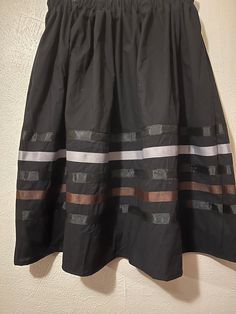 Native American Ribbon skirt- black, gray and brown ribbons. Ribbon Skirt - PLEASE CHOOSE YOUR SIZE BELOW! Skirt has an elastic waist that gives it the elusion of an A-line skirt.  Most skirts are 100% cotton or primarily cotton. Authentic Native American design for Pow Wow and Native American dances. They are approximately 32 inches long and most are about 32 inches in the waist.   RUSH SHIPPING: If you need to rush your shipping, (anything out of the normal) please note that I use USPS Priority Mail. You can change the shipping if you need to but please note, you will be charge for it and  I will also ask you to pay a RUSH fee. It is not fair to my other customers to have to move you to the front. There will be a fee of about $20 ($18 because shipping had to be added but I put in minimal Black Tiered Skirt With Elastic Waistband, Black Gathered Mini Skirt, Black Voluminous Mini Skirt, Black Lined Flared Skirt, Black Voluminous Skirt With Elastic Waistband, Long Black Skirt With Elastic Waistband, Black Long Skirt With Elastic Waistband, Black Midi Skirt With Elastic Waistband, Casual Black Voluminous Skirt