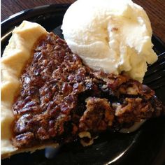 a piece of pie and ice cream on a black plate