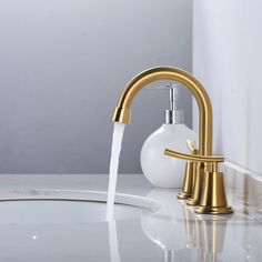 a faucet with water running out of it on a white countertop next to a sink