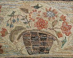 a close up of a rug with flowers and birds on it in the middle of an area