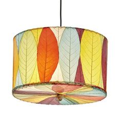 a multicolored lamp hanging from a ceiling with leaves printed on the lampshade