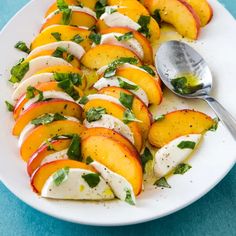 a white plate topped with sliced peaches covered in sour cream and minty garnish