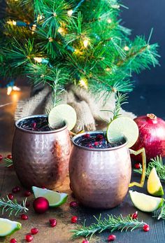 two glasses filled with liquid next to christmas decorations