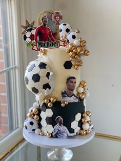 a three tiered cake decorated with soccer balls and photos on it's sides