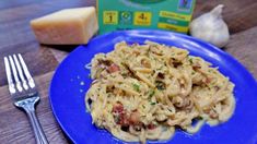 a blue plate topped with pasta and cheese next to a box of cheddar