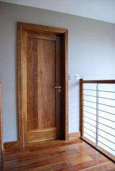 an empty room with a wooden door and railing