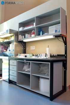 the inside of a medical office with lots of shelves and containers on top of it