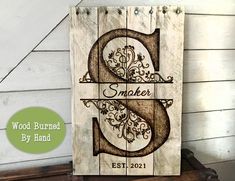 a wooden sign that says wood burned by hand with the letter s on it and an ornate design