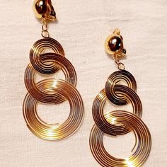 Abstract Metal Dangle Clip On Earrings Gold These Are Unique And Eye Catching They Hang 3.5 Inches Large Size Gold Metal These Are Very Lightweight On The Ear Easy To Wear They Are One Of A Kind These Earrings Are A Unique And Abstract Addition To Any Wardrobe Metal Small Hoop Clip-on Earrings, Trendy Metal Clip-on Hoop Earrings, Gold-tone Dangle Hoop Earrings For Party, Trendy Adjustable Metal Clip-on Earrings, Trendy Clip-on Dangle Hoop Earrings, Metal Wrap Earrings With Ear Wire For Party, Metal Wrap Earrings For Party With Ear Wire, Gold Metal Dangle Wrap Earrings, Round Metal Wrap Earrings For Party