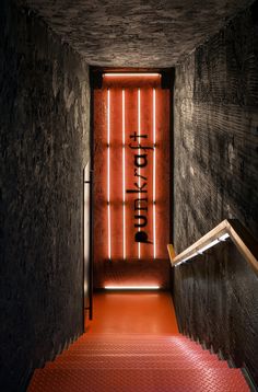 a red carpeted staircase leading up to a sign on the wall