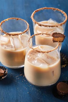 three glasses filled with ice cream on top of a blue table