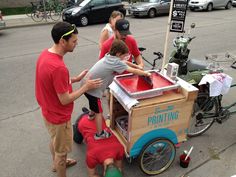 a group of people standing around a small cart