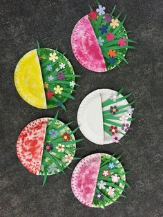 four paper plates with flowers on them sitting next to each other in the middle of a floor