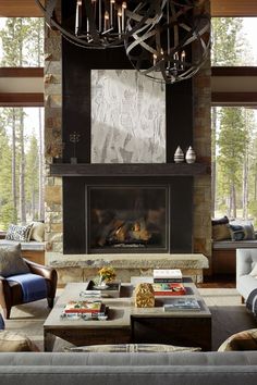 a living room filled with furniture and a fire place under a chandelier over a fireplace