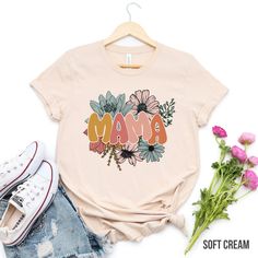 "Retro floral Mama t-shirt, mom shirt for Mom for Mother's Day, Mama T-shirt, Shirt for Mom for Mother's Day, Mama t-Shirt ❤️ Product Details: solid color unisex tees are super soft ring-spun cotton heather tees are a soft cotton-poly blend light fabric (4.2 oz/yd²) loved by all name brand Bella+Canvas runs true to size in a loose fit excellent quality print ❤️ HOW TO ORDER T-SHIRT 1-) Please, Check and Review all Photos. 2-) Select Your T-shirt Size. 3-) Click ADD TO CART and You can go back to add more product color and text color or You can complete the checkout process. 4-)Please Click \"Proceed to Check Out\" 5-) Finally, Your Custom Shirt will be ready to ship 2-4 Business Day. ❤️ SIZING Please reference our sizing chart in the photos to ensure correct size selection. Size down on th Mother's Day Shirt With Custom Print And Relaxed Fit, Pink Casual T-shirt For Mother's Day, Mother's Day Floral Print Short Sleeve Top, Relaxed Fit Shirt With Custom Print For Mother's Day, Floral Print Short Sleeve Top For Mother's Day, Floral Print Short Sleeve Top, Funny Print Short Sleeve Shirt For Mother's Day, Pink Graphic T-shirt For Mother's Day, Pink Graphic Print T-shirt For Mother's Day