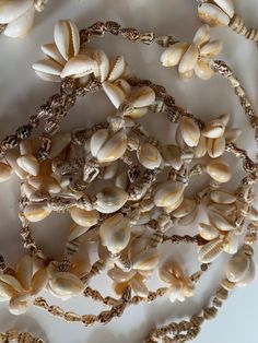 "Trio of vintage shell necklaces. These pieces bring you back to seaside lifestyle. None of them have maker marks or tags. None of them have clasps. All are in overall good vintage condition showing only minor age and wear. The pieces include a double row of shells that measures 17\". There is a necklace with groupings that measures 17\". The piece with the dangling bottom portion measures 14\" without the drop, and another 4.5\" with the drop. Shipping is included in the price. (Shipping may be Beach Shell Necklace Made Of Mother Of Pearl, Beach Shell Necklaces In Mother Of Pearl, Beach Shell Necklace In Mother Of Pearl, Vacation Shell Necklace With Mother Of Pearl, Mother Of Pearl Shell Necklace For Vacation, Vacation Mother Of Pearl Shell Necklace, Unique Shell Necklace For Beach, Beach Shell Necklace With Mother Of Pearl, Mother Of Pearl Shell Strand Necklace For Beach