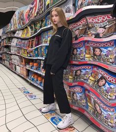 a woman standing on top of a skateboard in front of a store filled with magazines