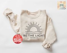 Be The Light,Be the Light Sweatshirt,Gift For Christians,Christian,Mathew 5:14 Sweatshirt,Bible Verse Sweater,Faith Outfit,Church Sweatshirt 🎁 Perfect Gift for Friends & Family! 🎁 Get high-quality, affordable, and personalized t-shirts that make a thoughtful gift for your loved ones. Each shirt is carefully printed by hand using the latest technology and eco-friendly, water-based inks. Thank you for supporting our small business! ❤️ 📏 What Size Should I Get? 📏 Please refer to the size chart Be The Light Shirt, Mathew 5, Sweatshirt Details, Be The Light, Religious Shirt, Faith Shirt, Christian Christmas, Jesus Shirts, Christian Clothing