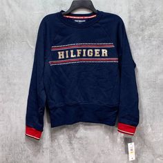 Tommy Hilfiger Blue Front Logo Crewneck Pullover Sweatshirt Sz M Ribbed Cuff And Hem Crewneck "Hilfiger" Logo On Chest Cotton, Polyester This Is A New With Tags Item. Please Refer To Images. Approx. Measurements: * Length: 22" * Sleeves: 24" * Chest: 22" Retail Price: $- Trendy Blue Tops With Ribbed Cuffs, Tommy Hilfiger Casual Tops With Ribbed Cuffs, Tommy Hilfiger Casual Top With Ribbed Cuffs, Casual Tommy Hilfiger Tops With Ribbed Cuffs, Tommy Hilfiger Letter Print Tops For Fall, Tommy Hilfiger Blue Winter Tops, Tommy Hilfiger Navy Winter Tops, Casual Blue Tommy Hilfiger Sweater, Blue Sporty Tommy Hilfiger Tops