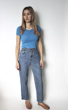 "DETAILS ◦ Vintage 1990s medium blue Levis 350 denim jeans ◦ Mid/high rise ◦ Three front pockets and two back pockets ◦ 4 button fly closure down front ◦ Five belt loops ◦ Straight leg, cropped fit Labeled 14 Regular Best Fit / Estimated Size | W 24\" - 24.5\" petite Measurements | Waist - 24.5\" Hips - 36\" Rise - 11\" Backrise - 12.5\" Inseam - 27\" Length -37.75\" Thighs - 21.5\" Circumference at ankle - 14\" Tag/Label | Levis 350, white tab Material | 100% cotton Condition | Good, some stain Classic High Waist Blue Jeans, 90s Style Mid-rise Blue Jeans, 90s Style Blue Mid-rise Jeans, 90s Blue Jeans With Five Pockets, 90s Blue Straight Leg Jeans, High Waist Blue Jeans For Everyday, 90s High Rise Blue Jeans, 90s Style Denim Jeans For Everyday, Vintage Blue Jeans For Everyday