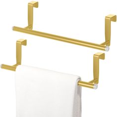 two gold towel racks with white towels hanging from the top and one in the middle