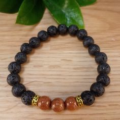 The bracelet contains two stones that are vital to our wellbeing: Goldstone and Lava Stone. The sparkles of Goldstone are symbolic of light that can always be found in the darkness. It deflects unwanted energies and is highly regarded in the spirit realm as a protective mineral. Lava Stone is a grounding stone that strengthens the connection to Mother Earth. A calming stone, it is instrumental in dissipating anger. It promotes positive changes where needed in behavioral issues. Our Brown Goldsto Spiritual Lava Stone Stretch Bracelet With Natural Stones, Spiritual Lava Stone Stretch Bracelet Gift, Adjustable Lava Stone Bracelet For Meditation, Adjustable Lava Stone Stretch Bracelet For Meditation, Meditation Bracelets With Natural Lava Stones, Lava Stone Bracelets With Natural Stones For Gift, Gift Bracelets With Natural Lava Stones, Spirit Realm, Positive Changes