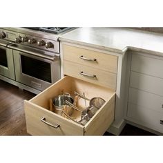 an open drawer in the middle of a kitchen