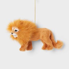 a stuffed toy lion hanging from a gold chain