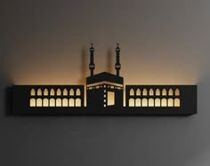 a wall mounted light with an image of a mosque on it's side and lights in the middle