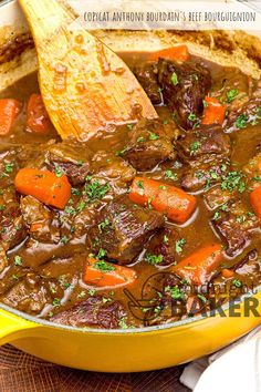 a yellow pot filled with beef stew and carrots