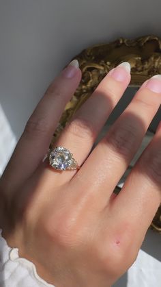 a woman's hand with a diamond ring on it